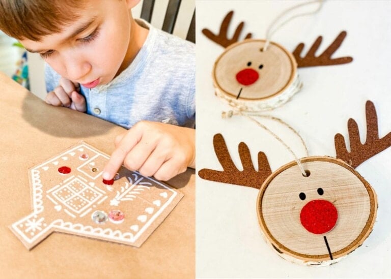A child is decorating a paper gingerbread house with white and red accents on the left side of the image. On the right side, there are two reindeer ornaments made from wooden slices, featuring red noses and antler decorations—capturing the joy of a Christmas craft.