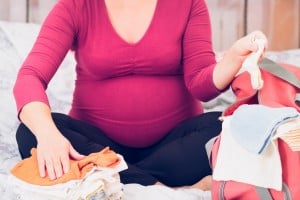 Pregnant woman packing hospital bag for labor and delivery