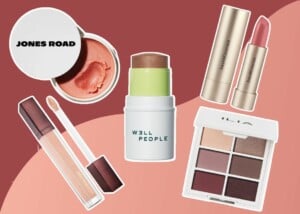 Various makeup products arranged on a red and pink background.