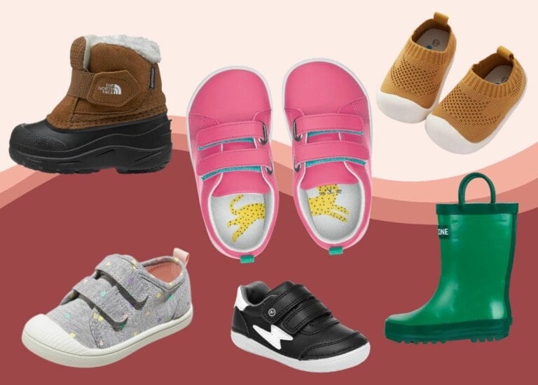 An assortment of children's shoes, considered the best shoes for toddlers, are arranged against a background with red and beige tones. The collection includes pink sneakers with straps, tan knitted slip-ons, green rubber boots, black and white velcro sneakers, grey star-patterned sneakers, and brown winter boots.