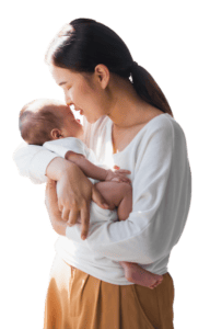 Young Asian mother holding her newborn baby in bedroom. She is closing her eyes about to give her baby a kiss.